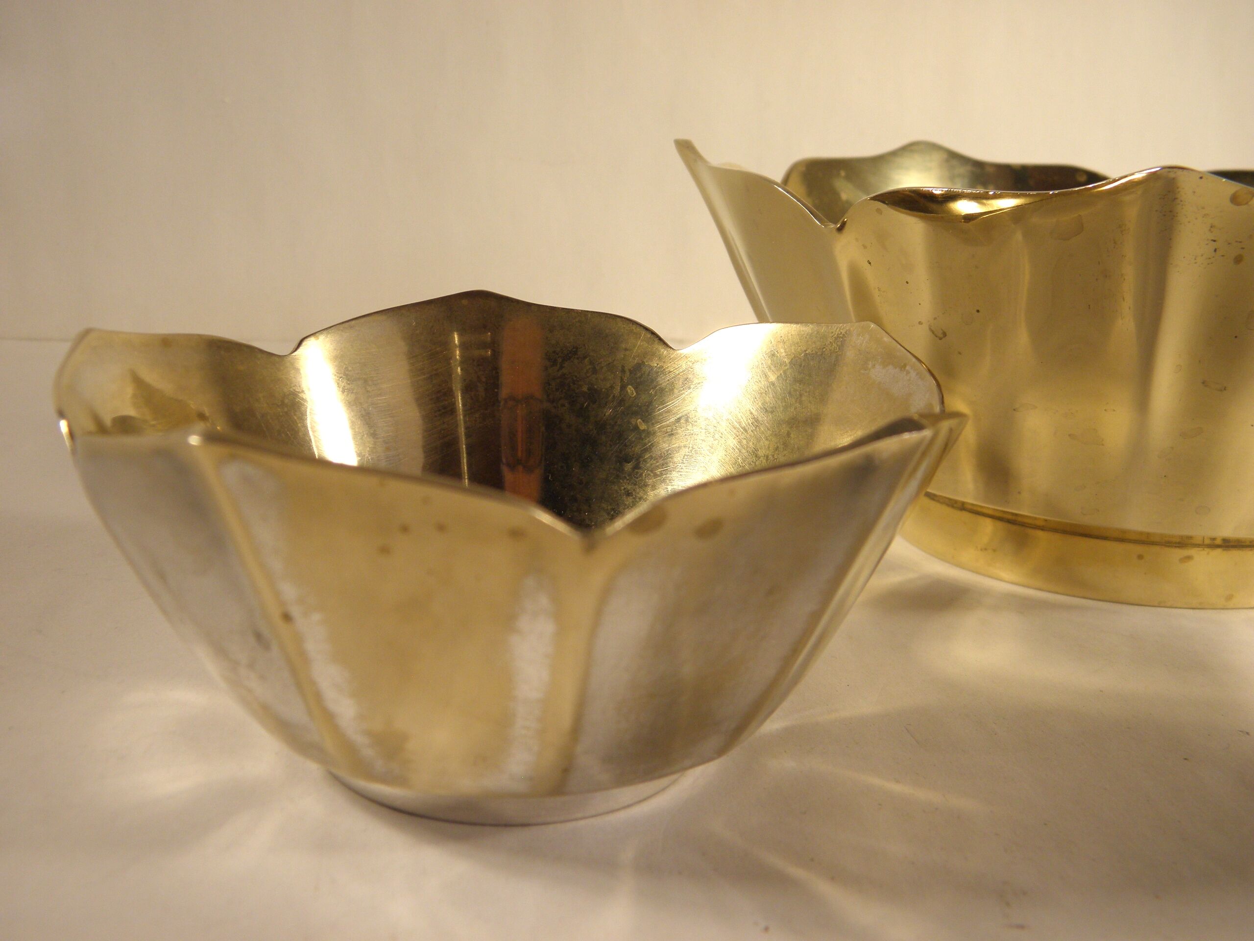 Two brass trundle cups