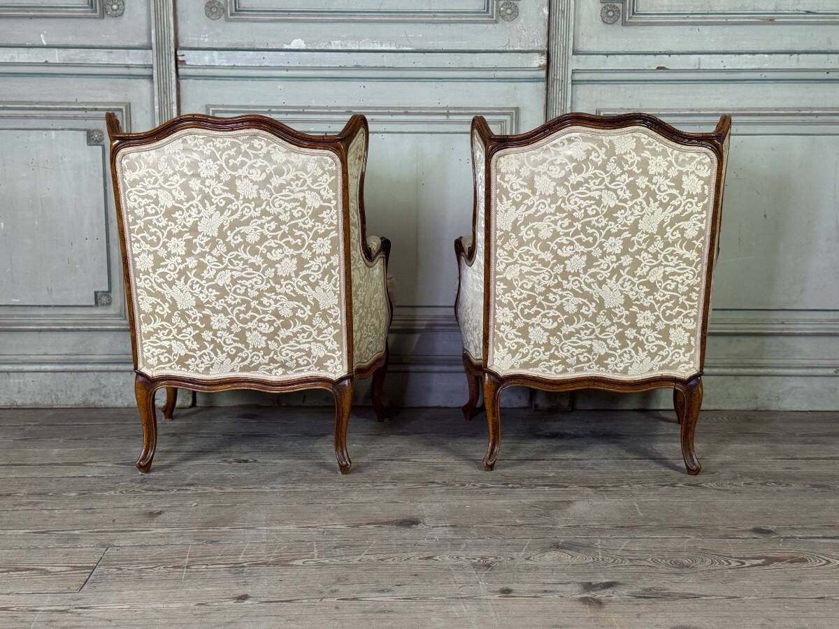 Pair of small Louis XV style wing chairs in carved walnut, Bosson stamp