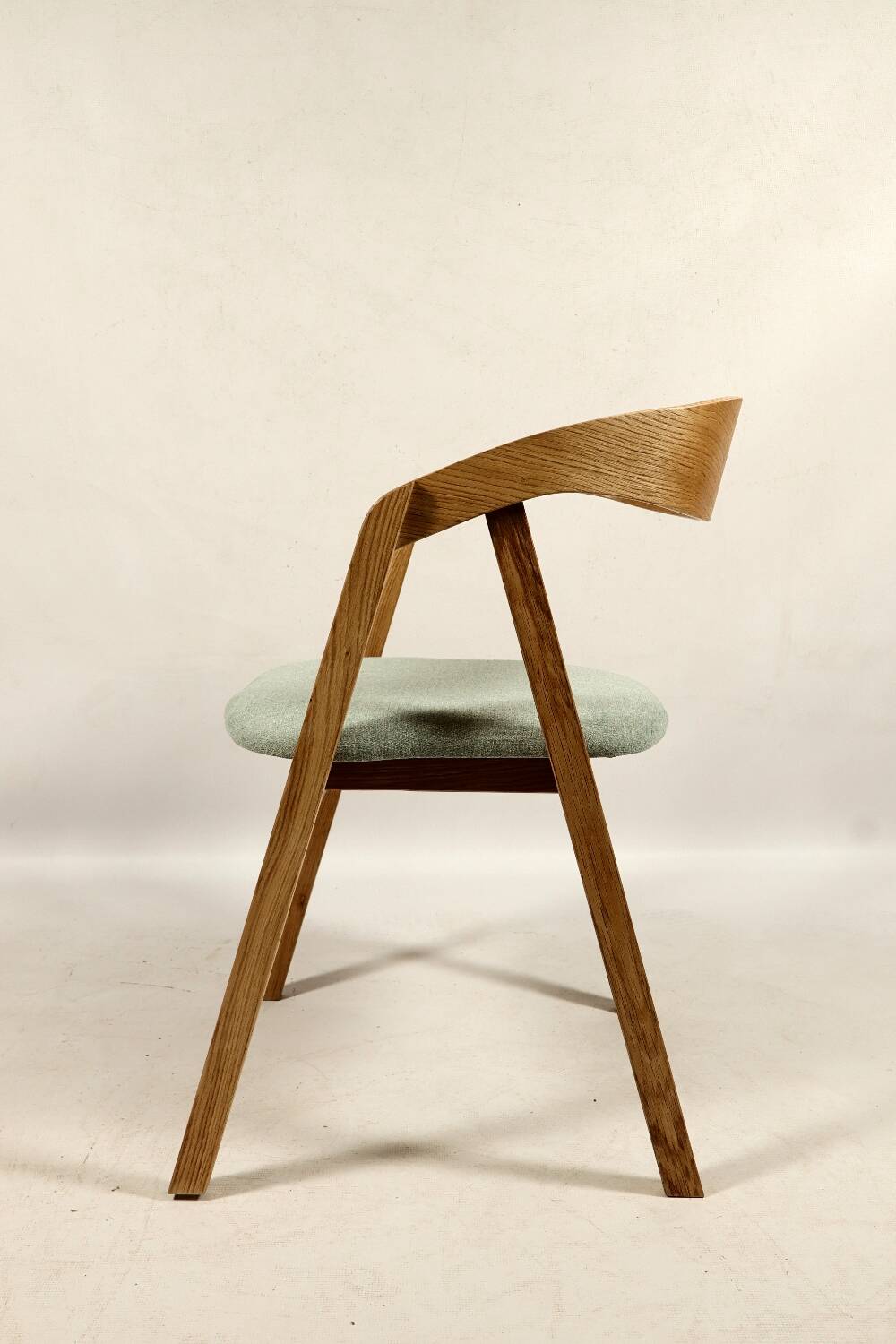 Vintage dining chair in light oak with natural linen pastel green fabric.