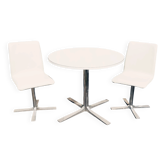 Round table and vintage dining chairs in formica and faux leather.