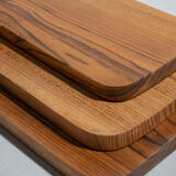 Trio of rounded rectangular trays or cups in monoxyl teak L:35