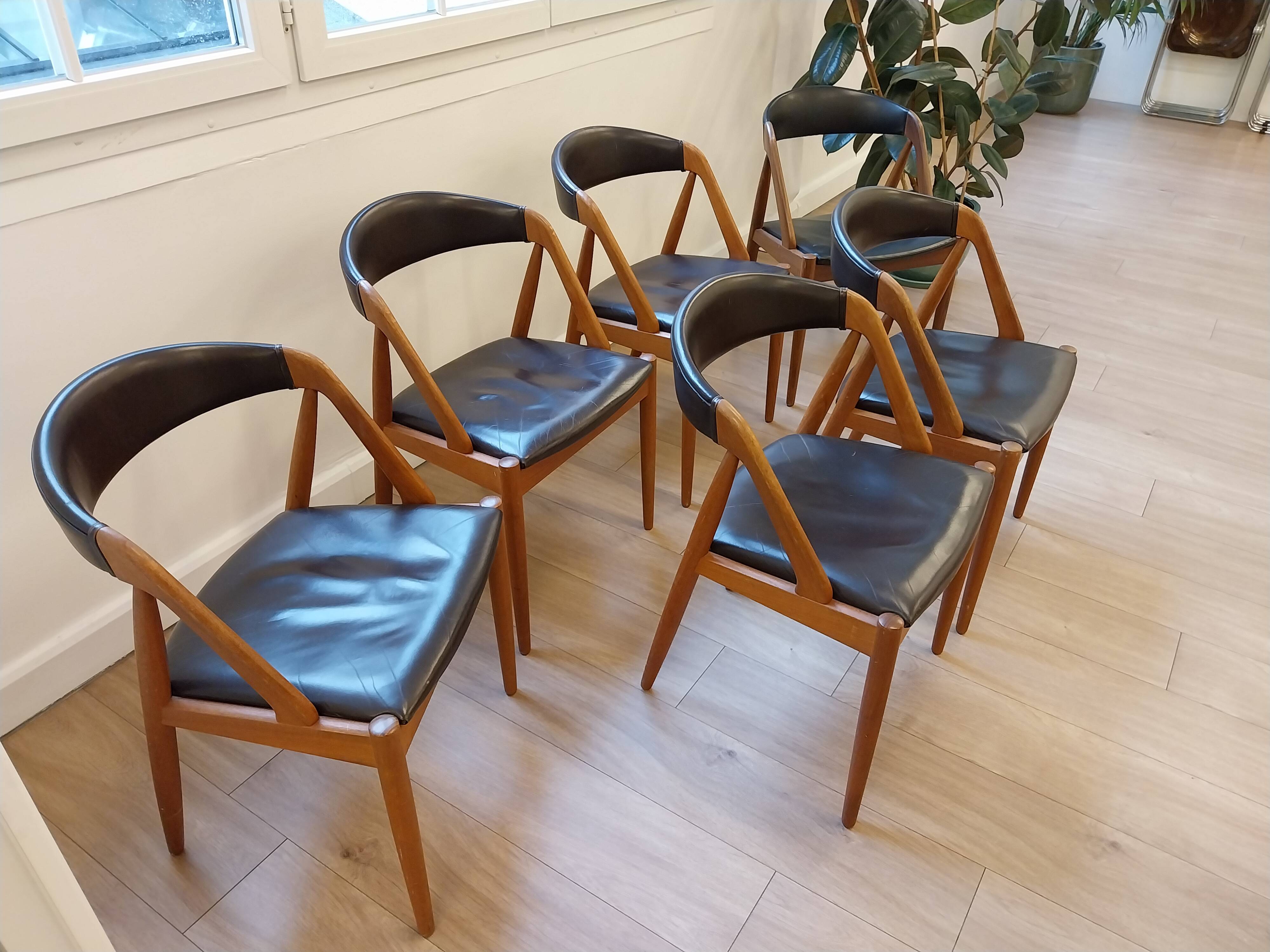 Set of 6 vintage Kai Kristiansen chairs in solid teak and black faux leather.