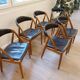 Set of 6 vintage Kai Kristiansen chairs in solid teak and black faux leather.