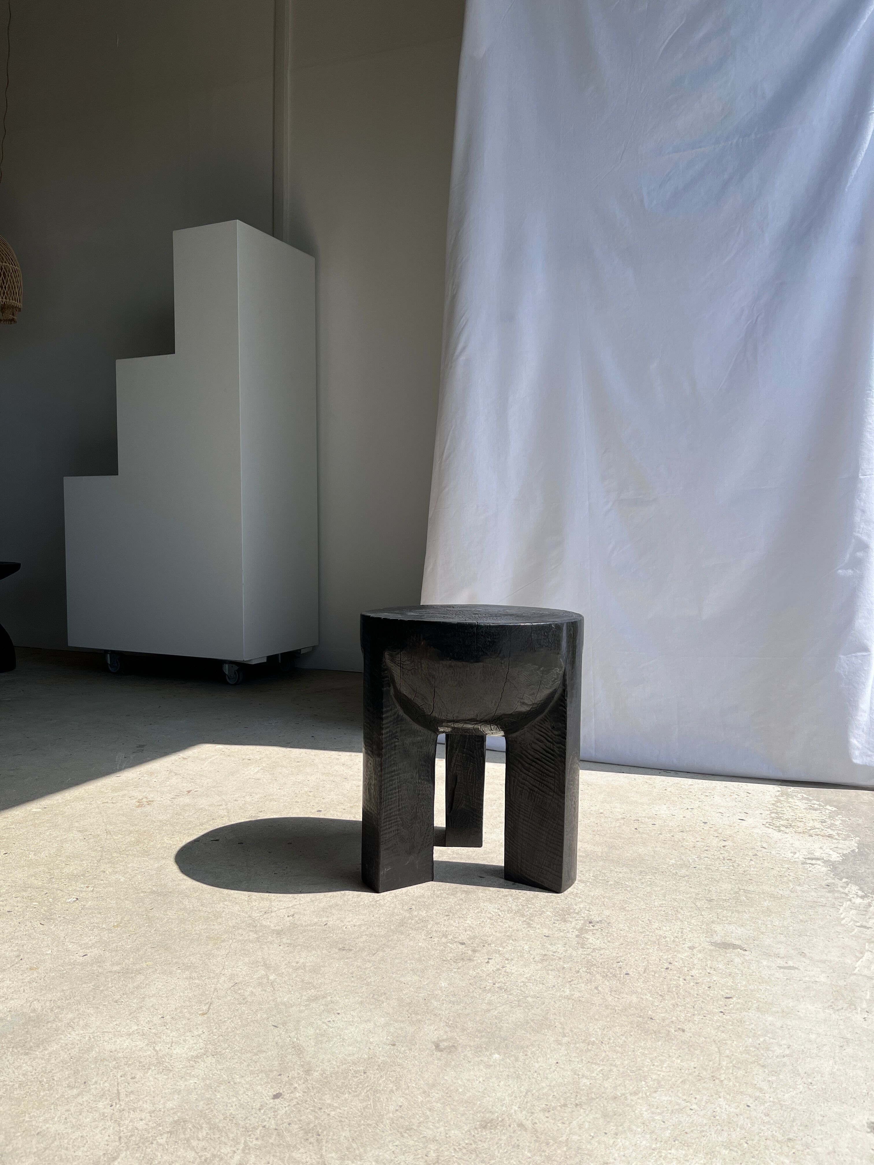 Black mango wood tripod side table with a semi-spherical top, height: 45 cm, diameter: 44 cm.