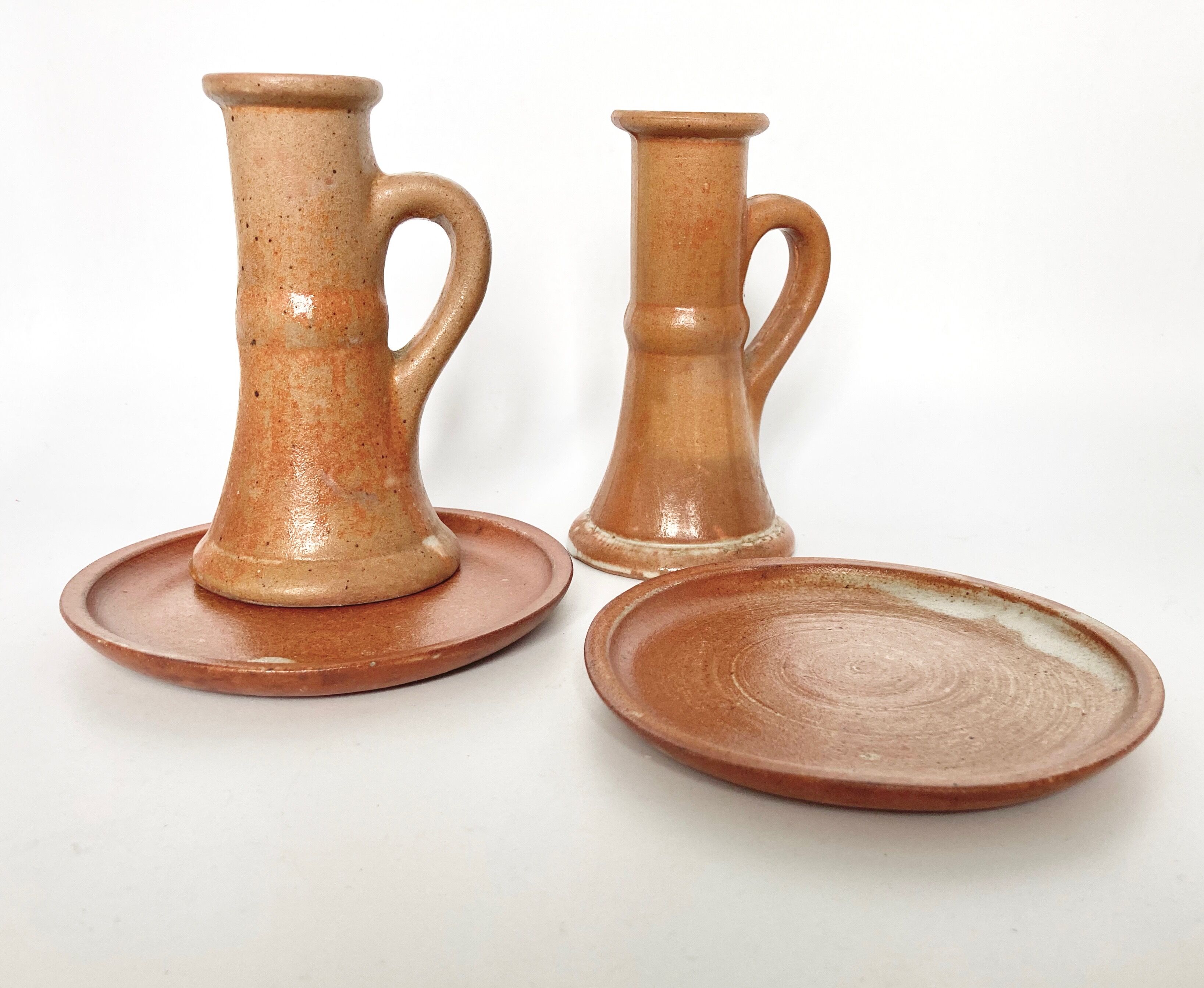 Pair of candlesticks and two sandstone cups