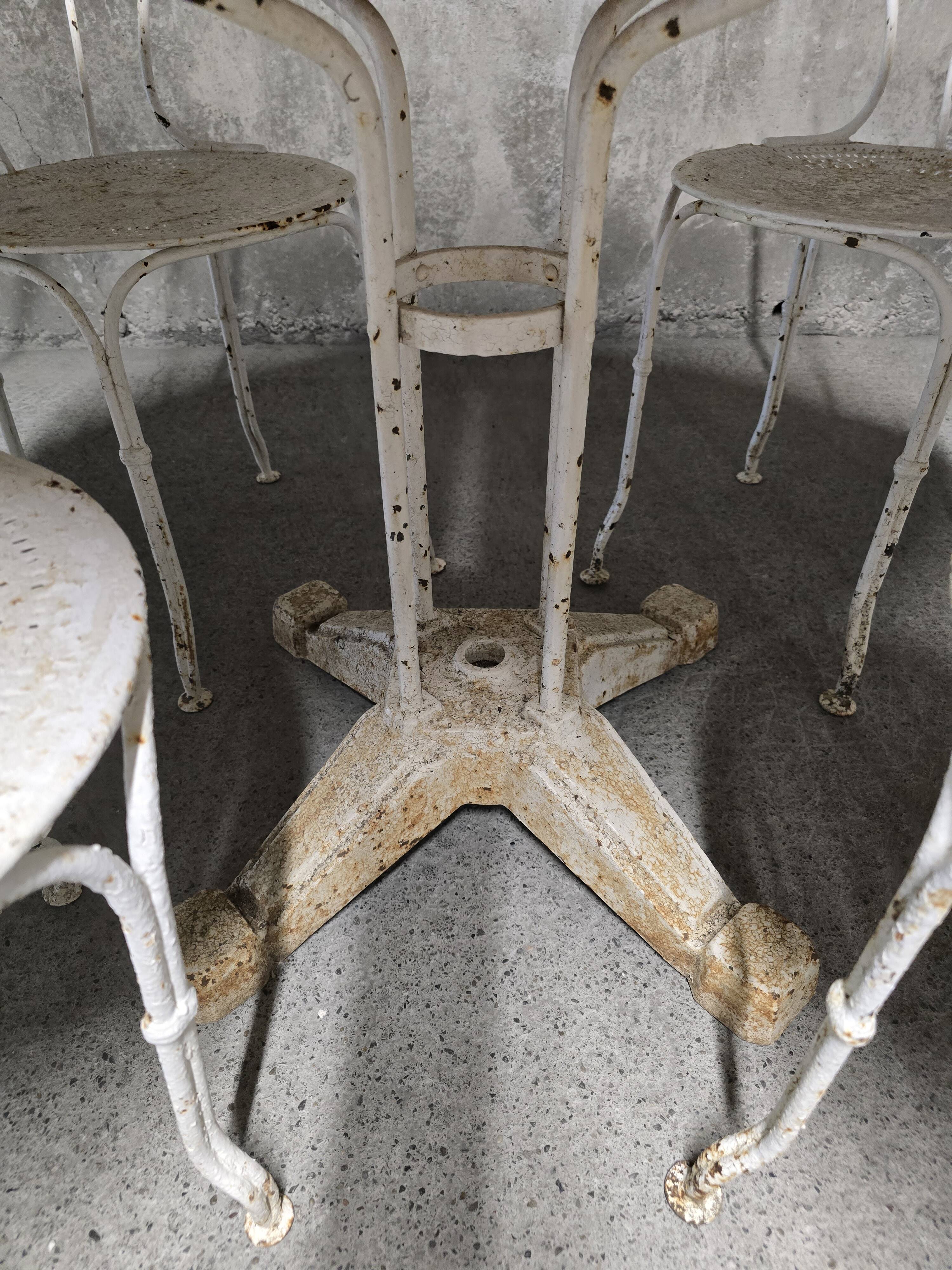 Antique painted wrought iron garden furniture, round table and four chairs.