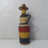 Old bottle dressed in scoubidou style rattan