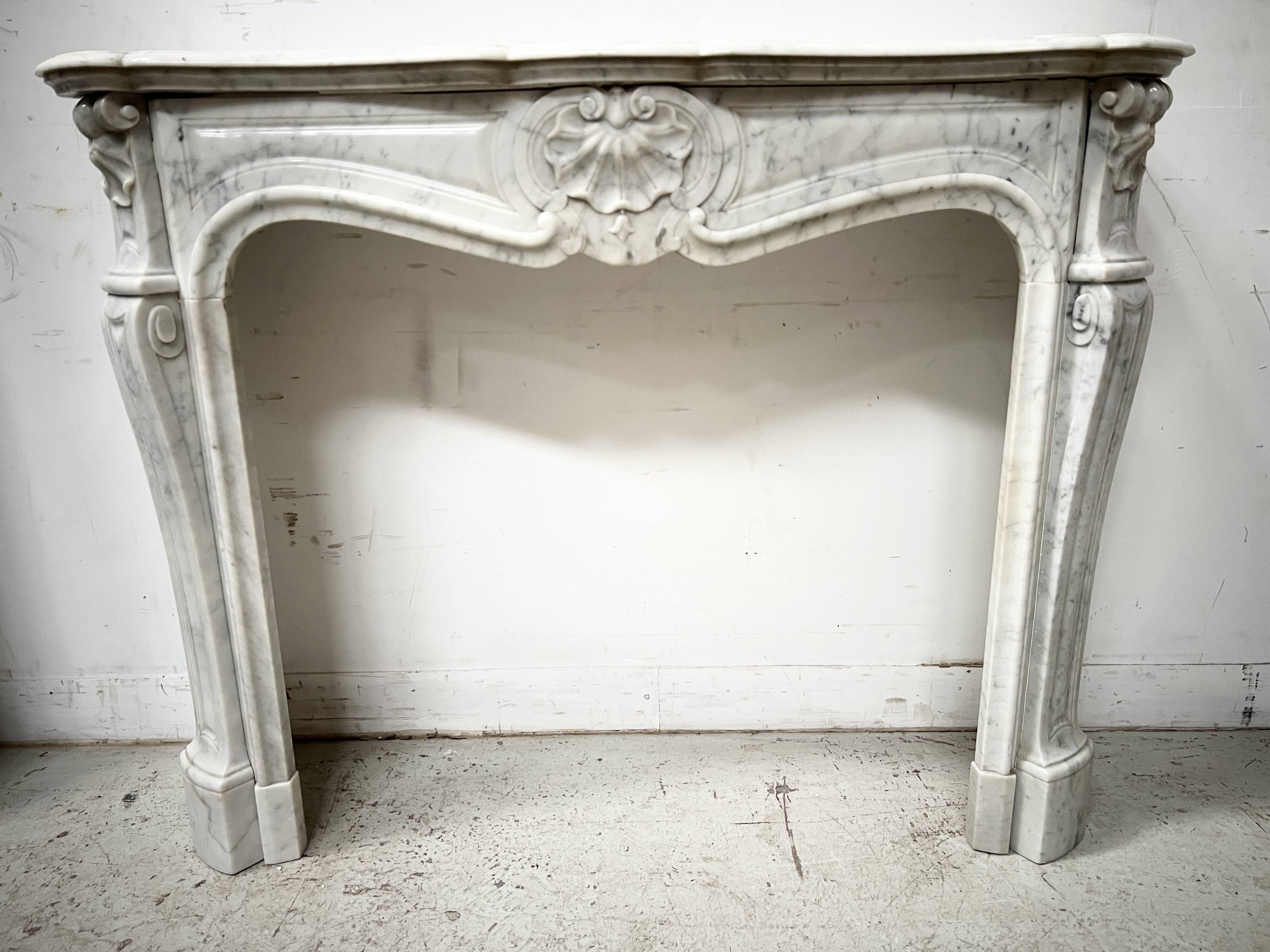Louis XV style fireplace in veined white marble, 20th century.