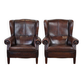 Set of two in very good condition dark sheepskin leather wingback armchairs