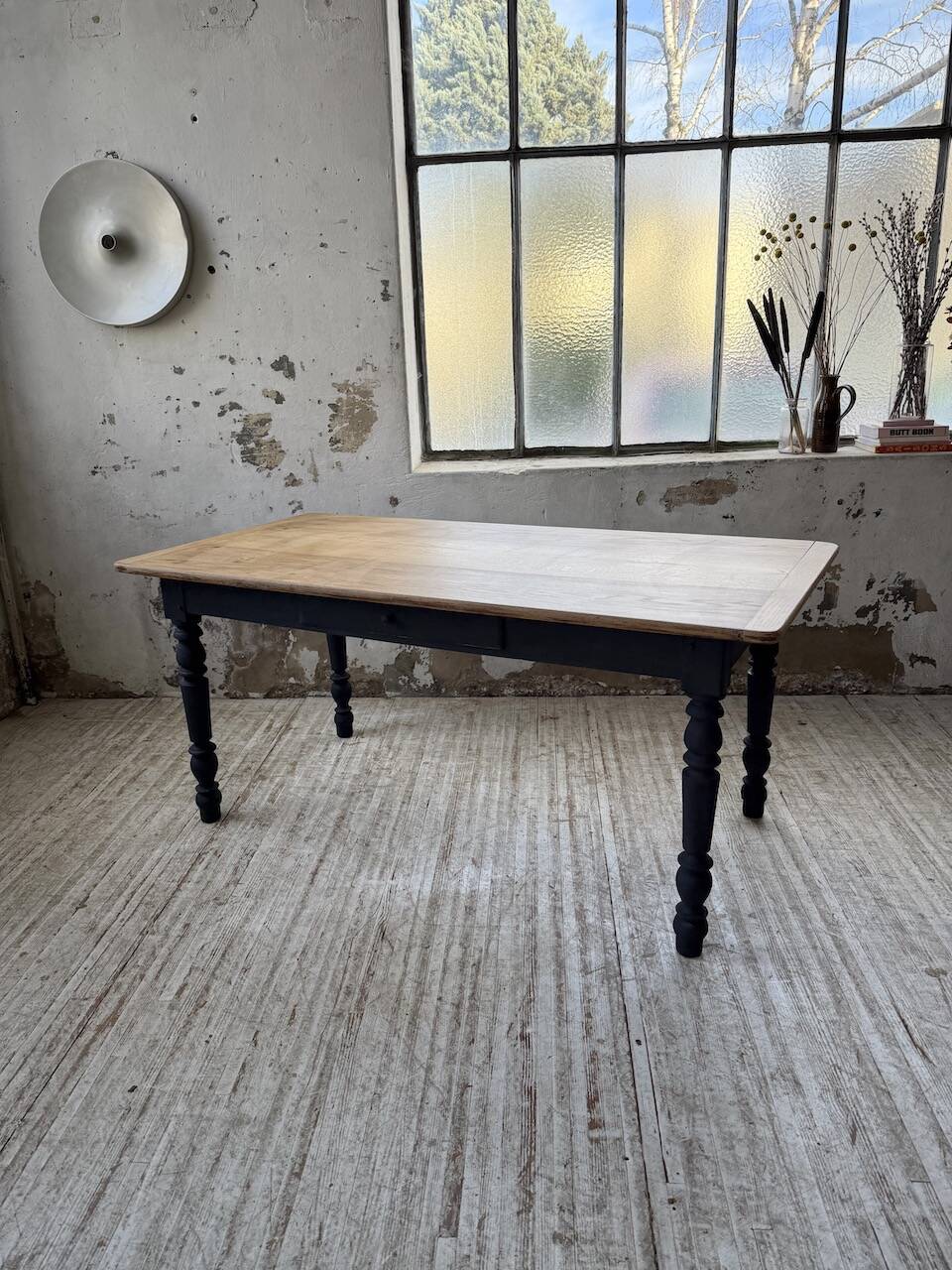 Oak farmhouse table with turned black legs.