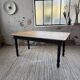 Oak farmhouse table with turned black legs.
