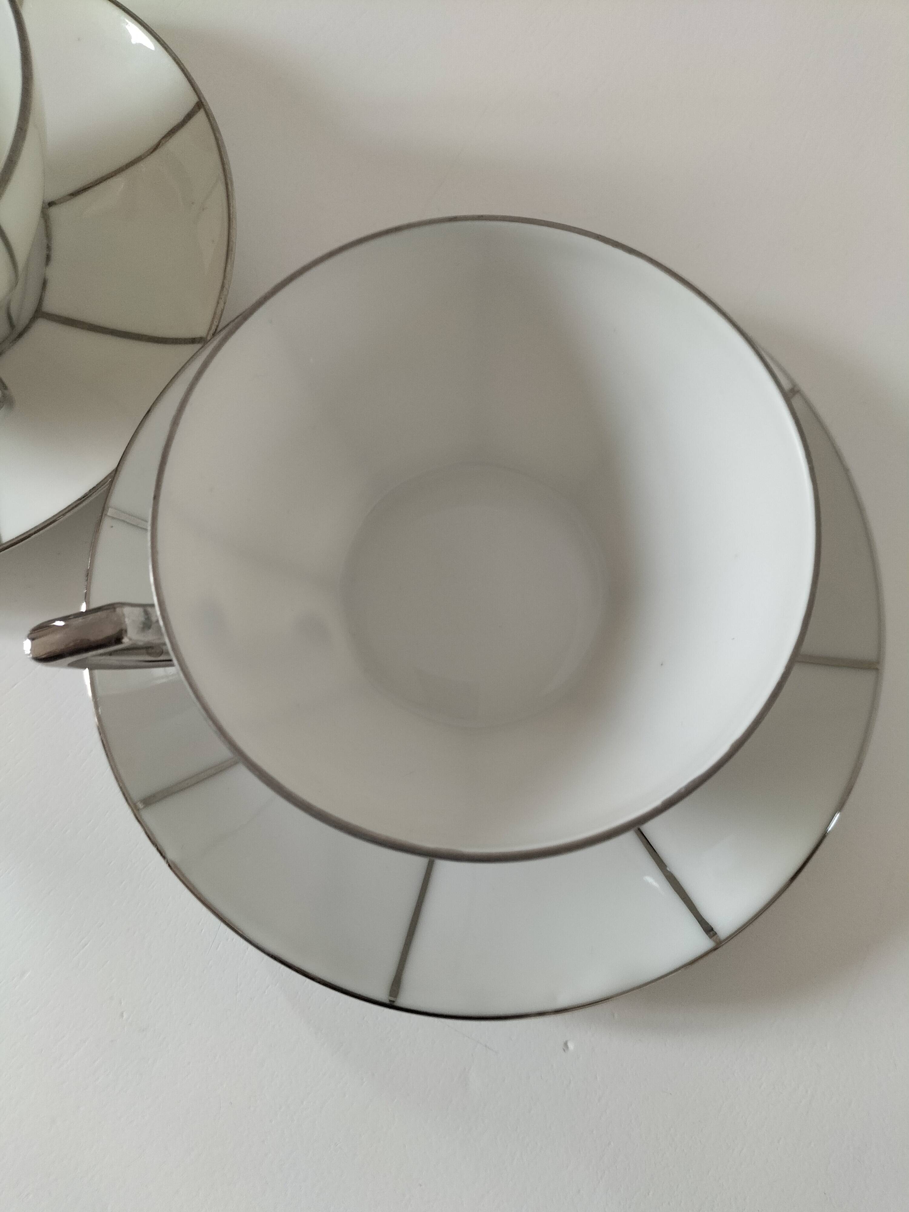 Two Art Deco porcelain cups and saucers with silver trim.