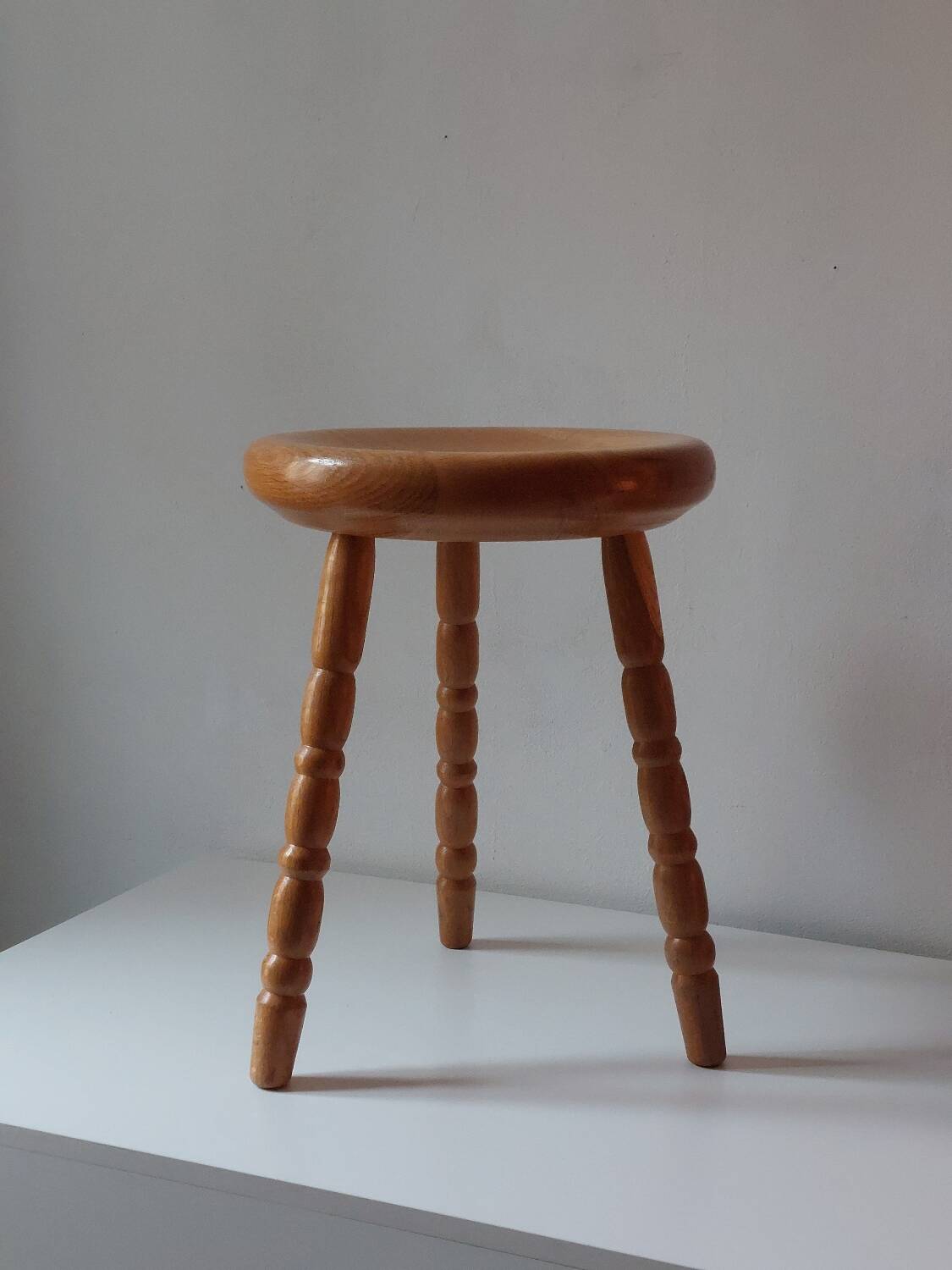Vintage en bois tourné tabouret du milieu du siècle avec un siège épais.