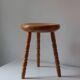 Vintage en bois tourné tabouret du milieu du siècle avec un siège épais.