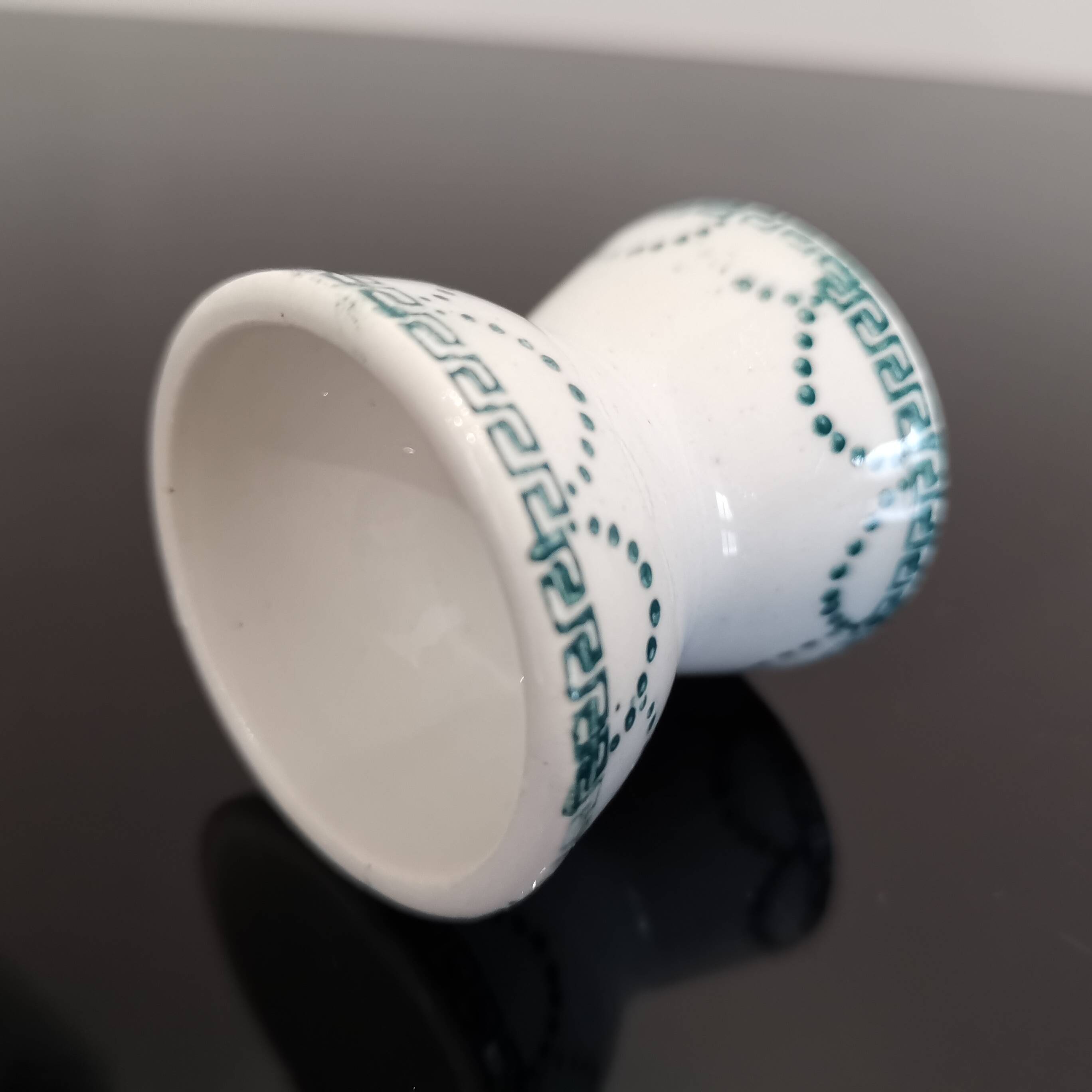 Old porcelain diabolo egg cup decorated with green frieze and garlands