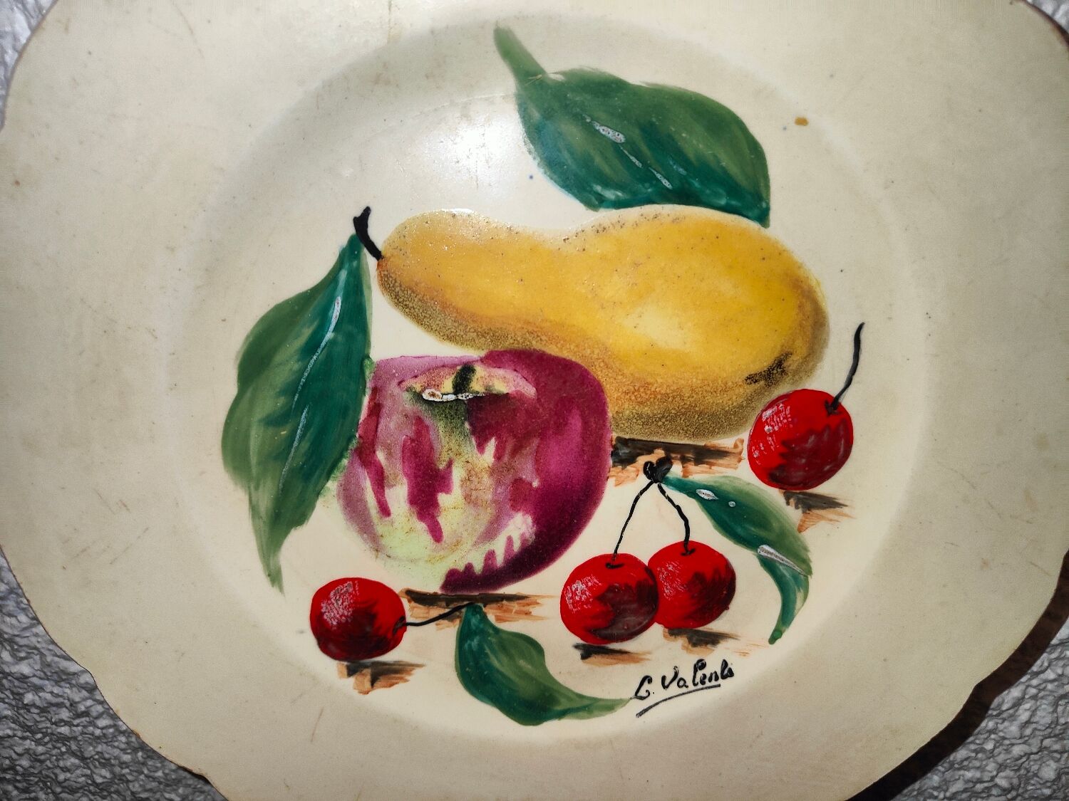 Faience plate in Longwy enamels signed Léa Valenti representing Fruits
