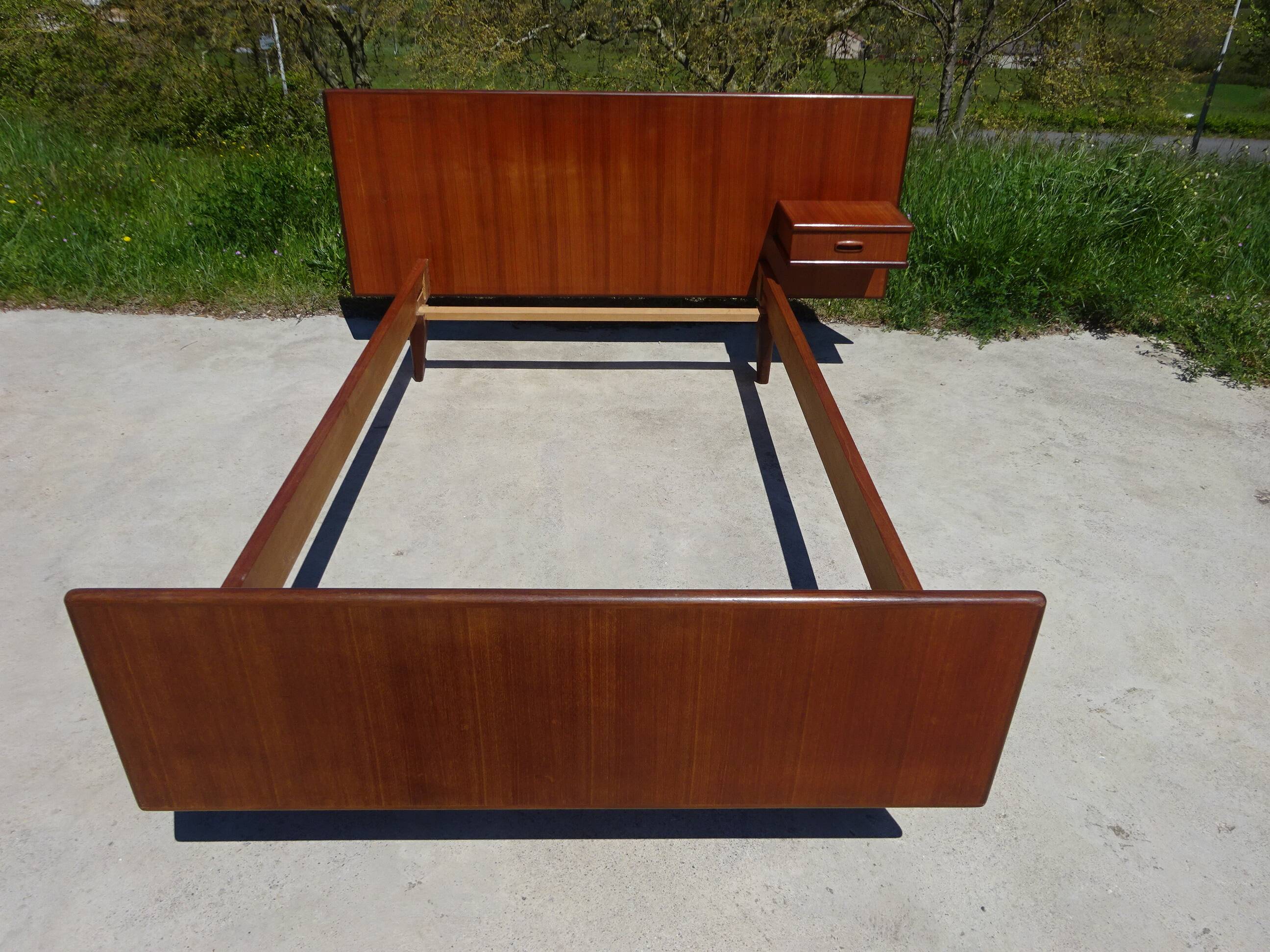 Vintage bed in teak with integrated bedside table.