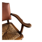 Brutalist armchair with a rattan seat and leather backrest.