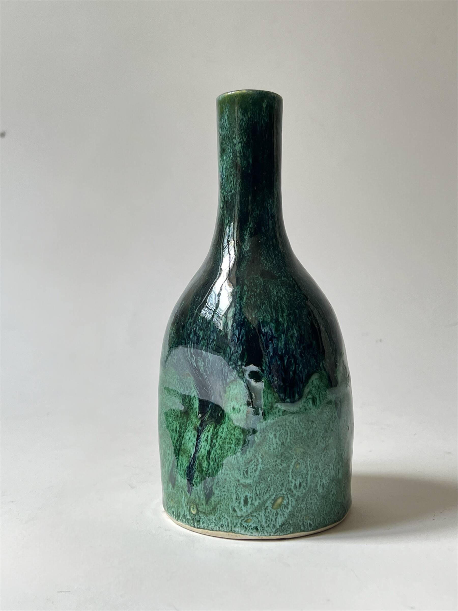 Ceramic vase with a glazed blue/green finish.