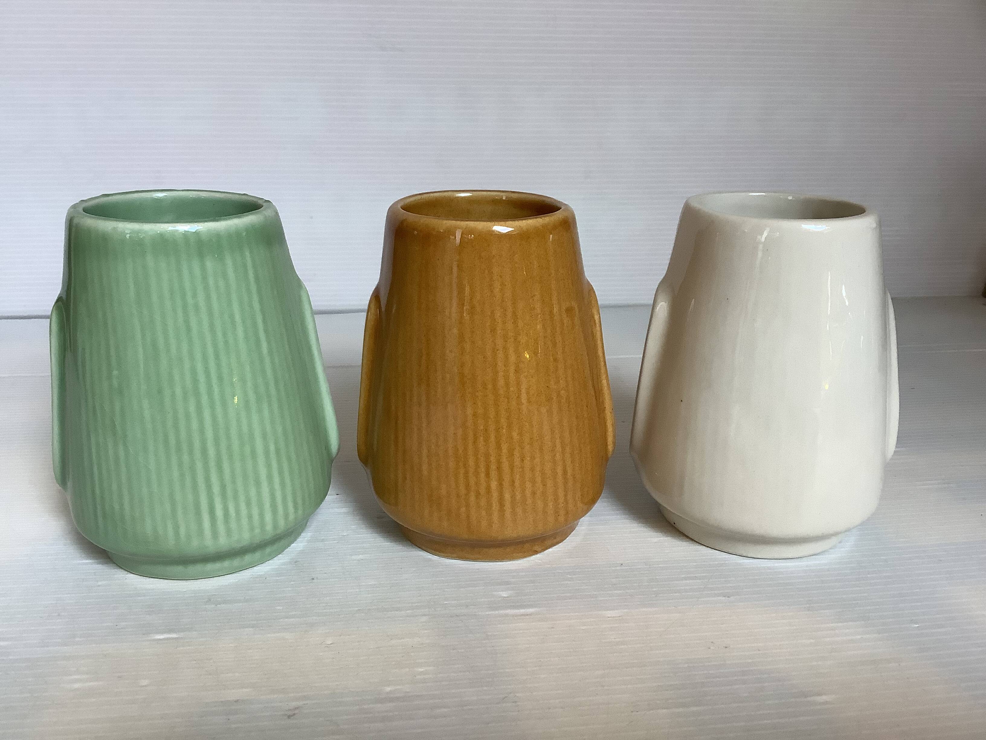 Set of three small Moai-style head vases.