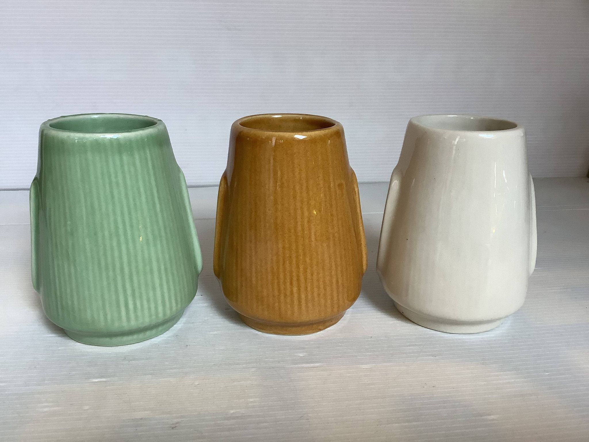 Set of three small Moai-style head vases.