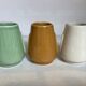 Set of three small Moai-style head vases.