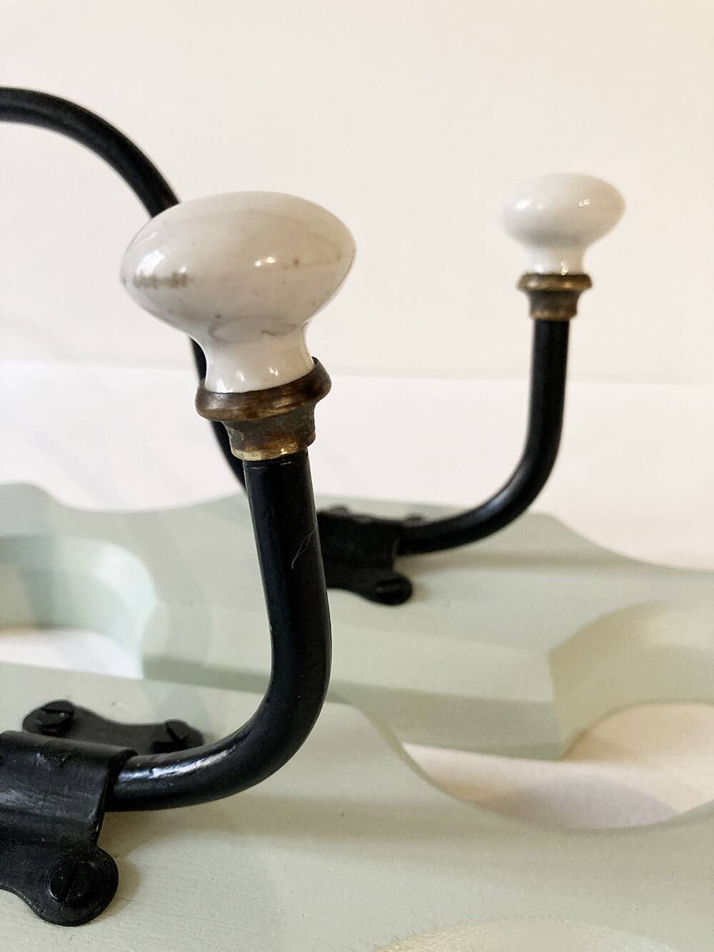 Antique metal and porcelain coat hooks, painted wooden support