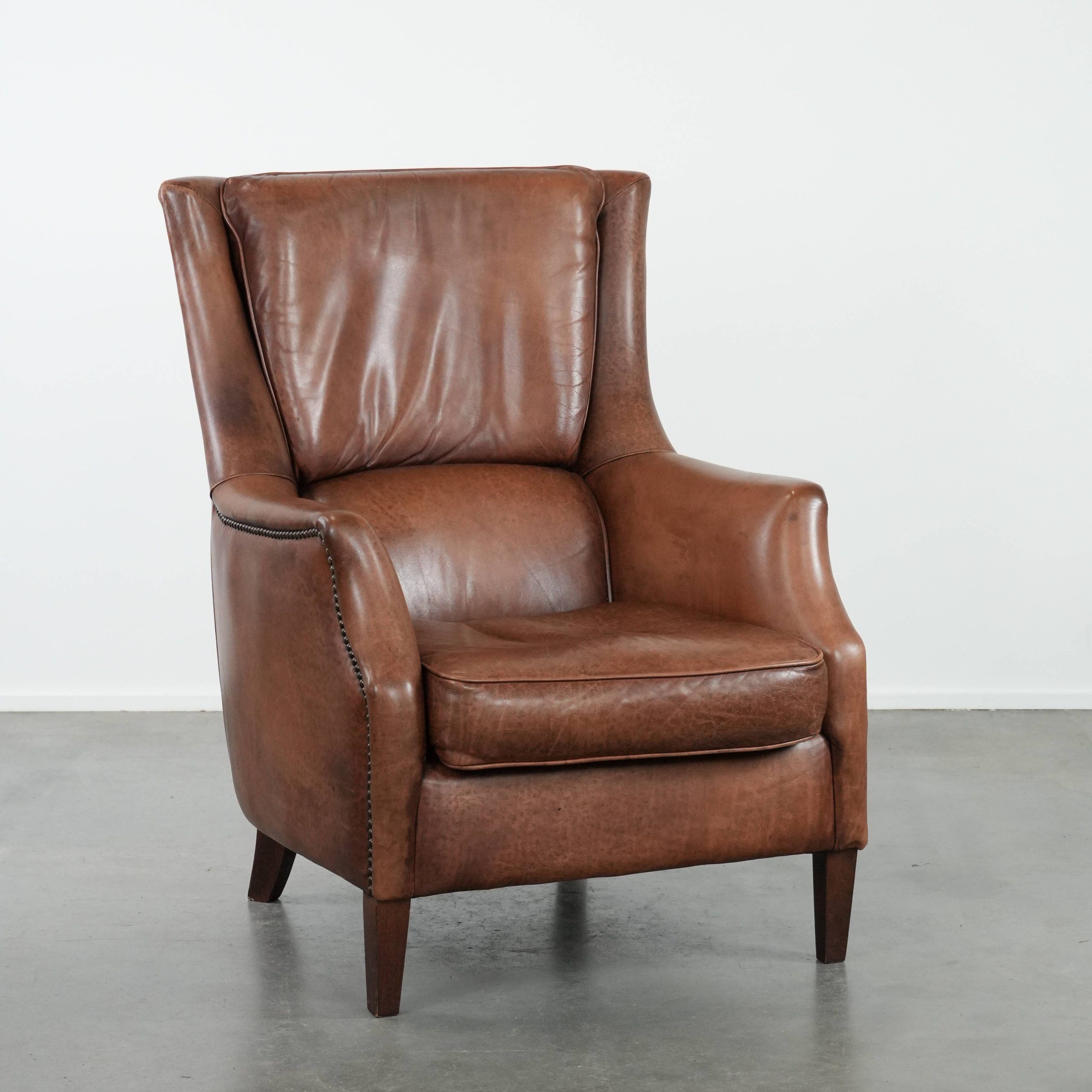 Cognac brown cow leather armchair with decorative nail finish