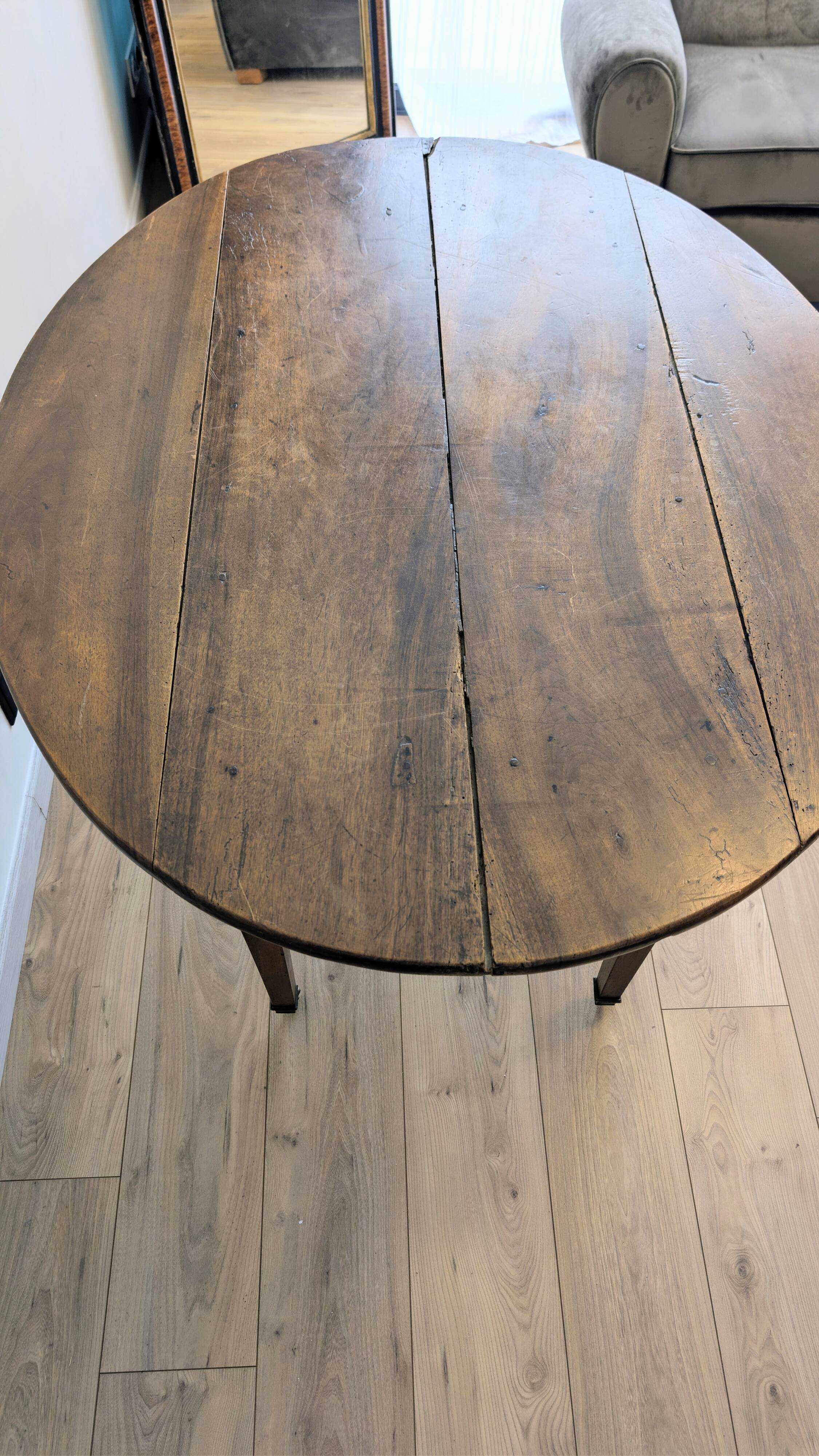 Antique wooden folding table with a patina and brass wheels.