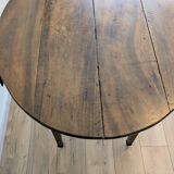 Antique wooden folding table with a patina and brass wheels.