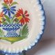 Pair of antique plates in popular earthenware with a floral basket decoration on the edge.
