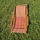vintage wooden deck chair with striped fabric and footrest
