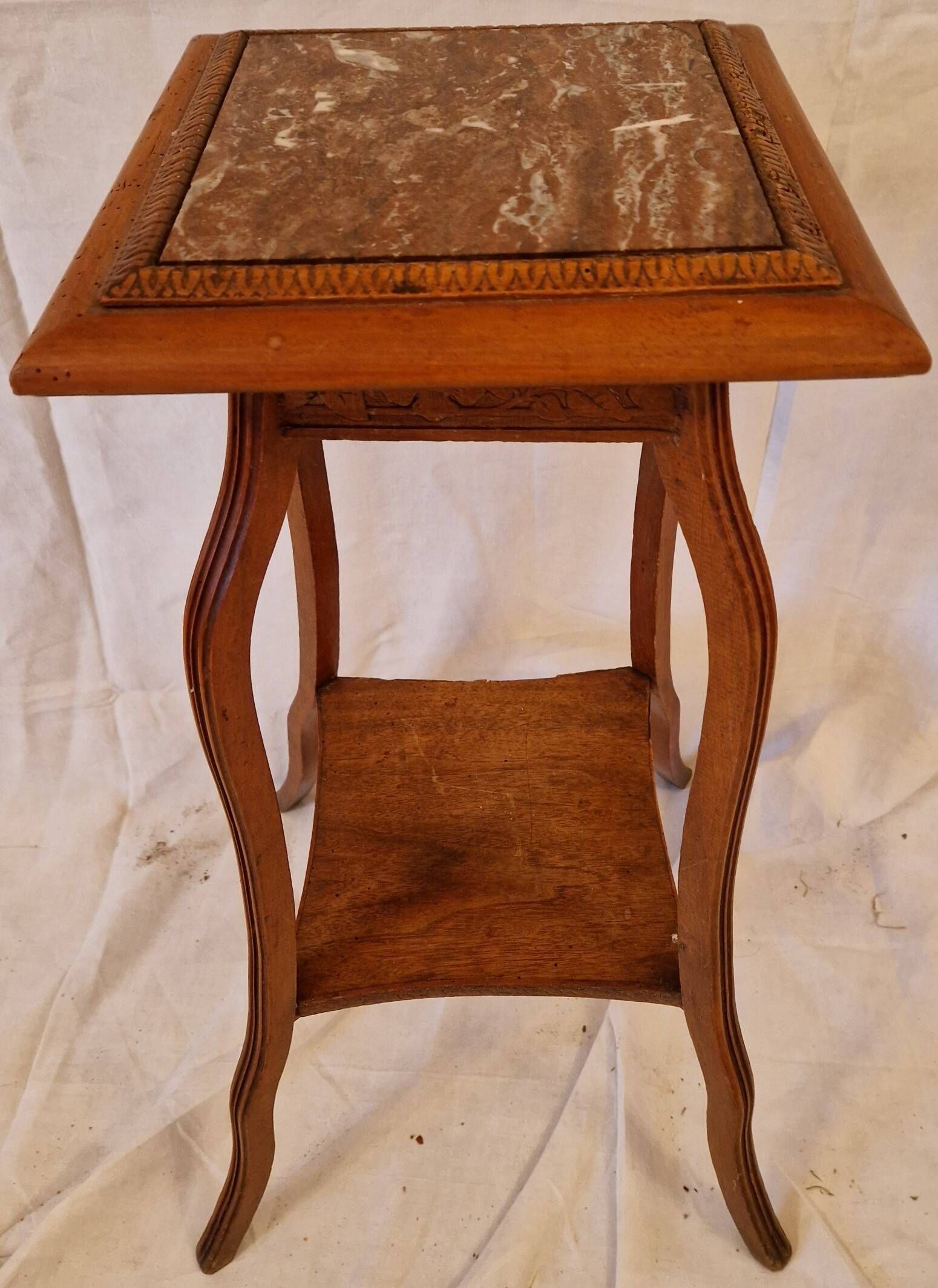 Antique Art Nouveau pedestal table with carved wood and marble top.