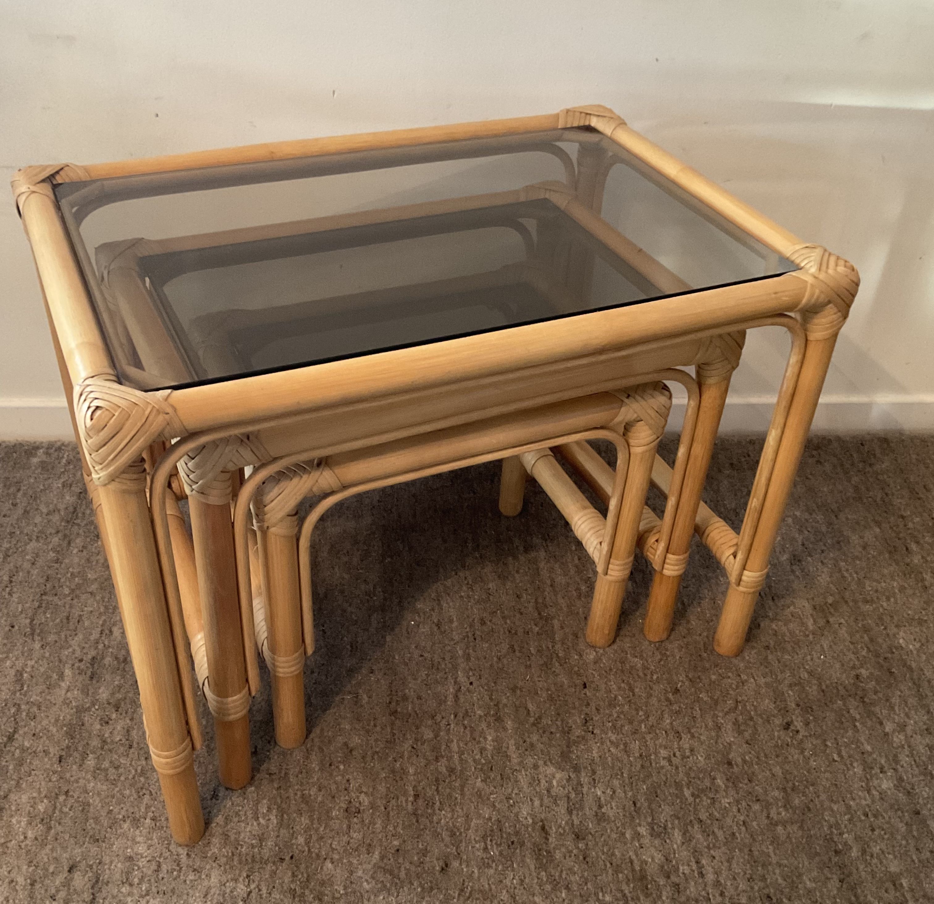 Trio of vintage pull-out tables in rattan and smoked glass 70s