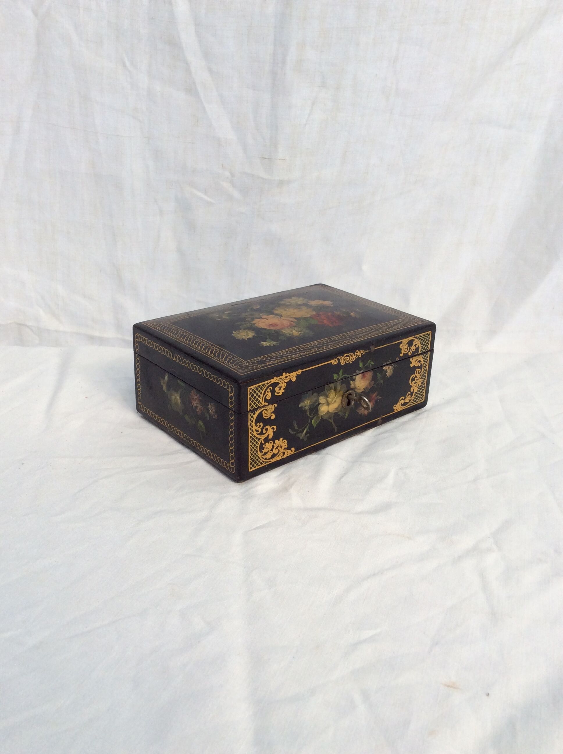 Old black wooden box adorned with roses with keys
