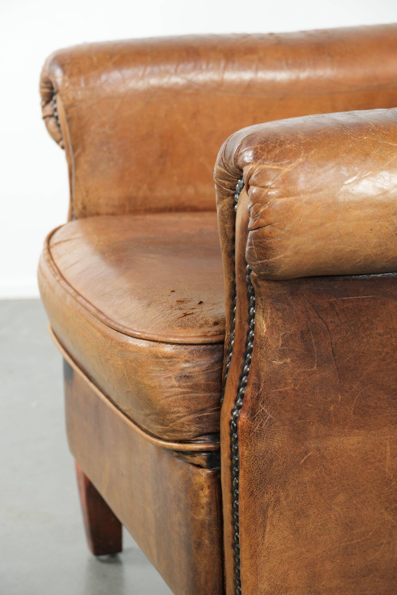 Sheepskin armchair with a beautiful vintage look and decorative nail finish