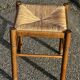 1950s turned wooden stool with a straw seat.