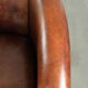 Sheepskin club armchair with deep warm colours and black piping