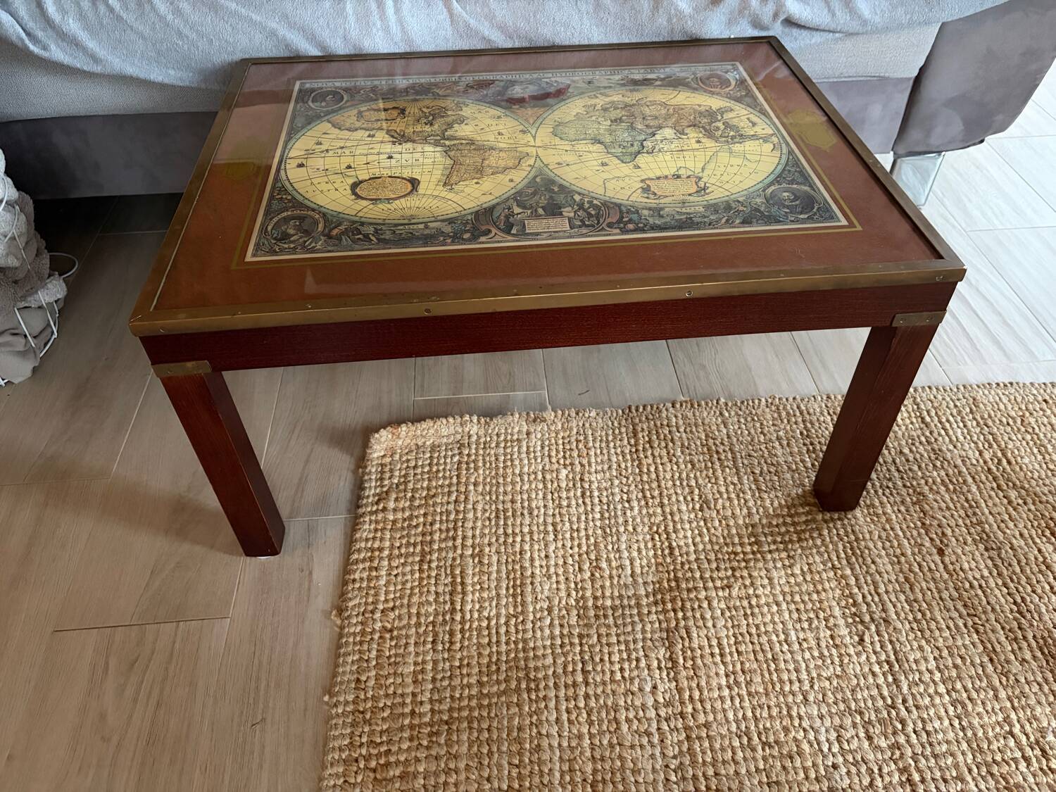 Wood and brass coffee table with a world map under glass.