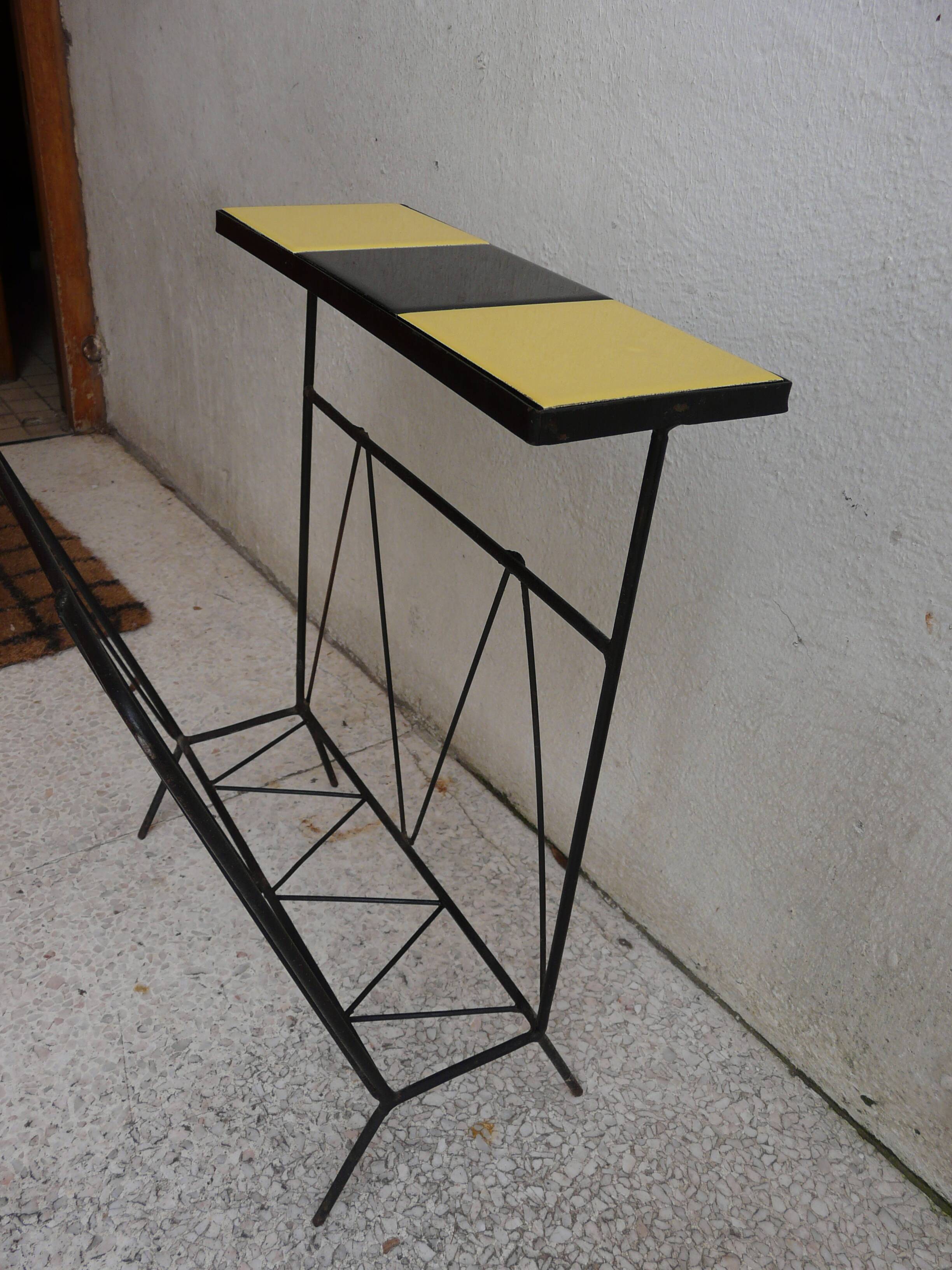 Black metal magazine rack and yellow and black tiled shelf.