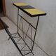 Black metal magazine rack and yellow and black tiled shelf.