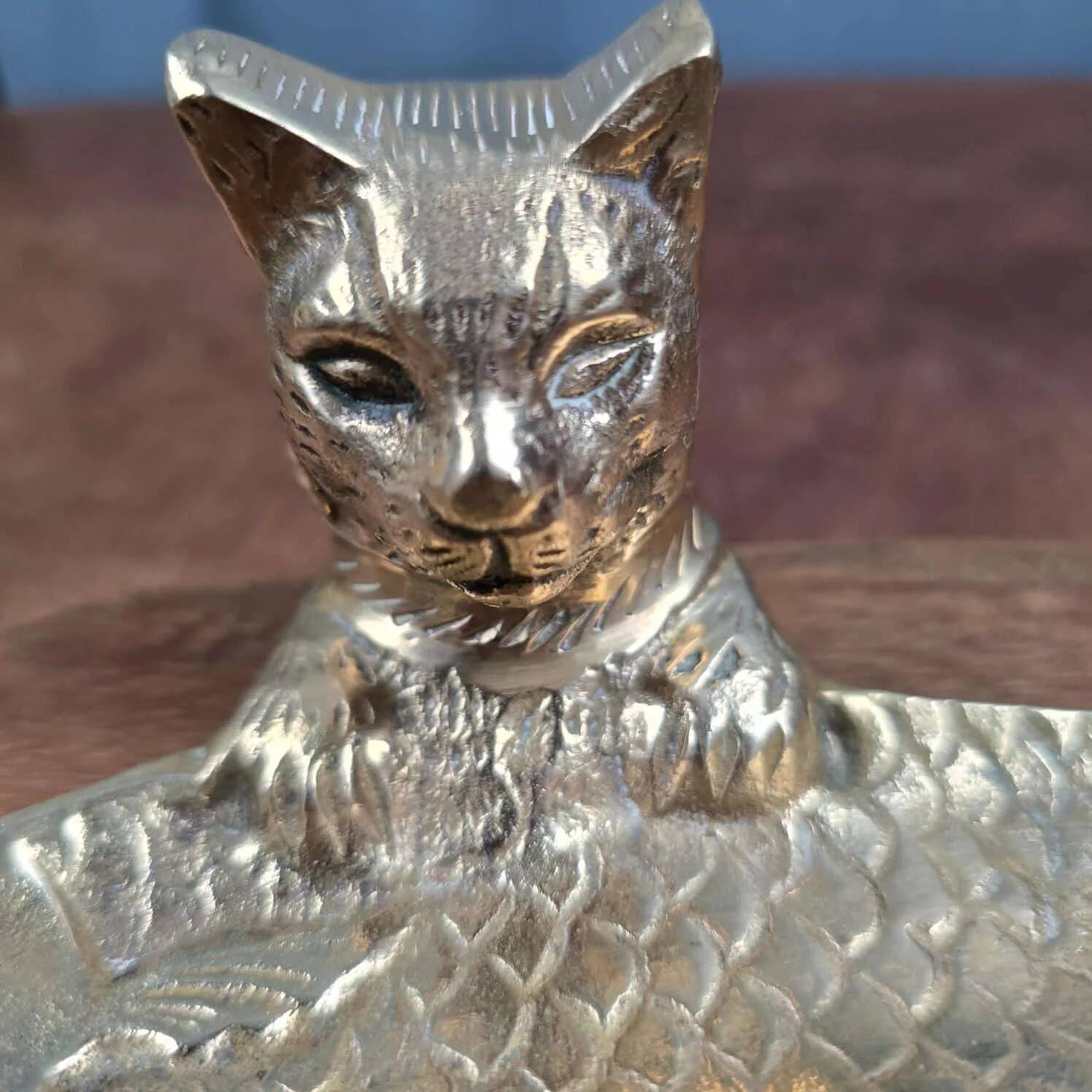 Vintage cat fish catchall in brass on a solid wood base.