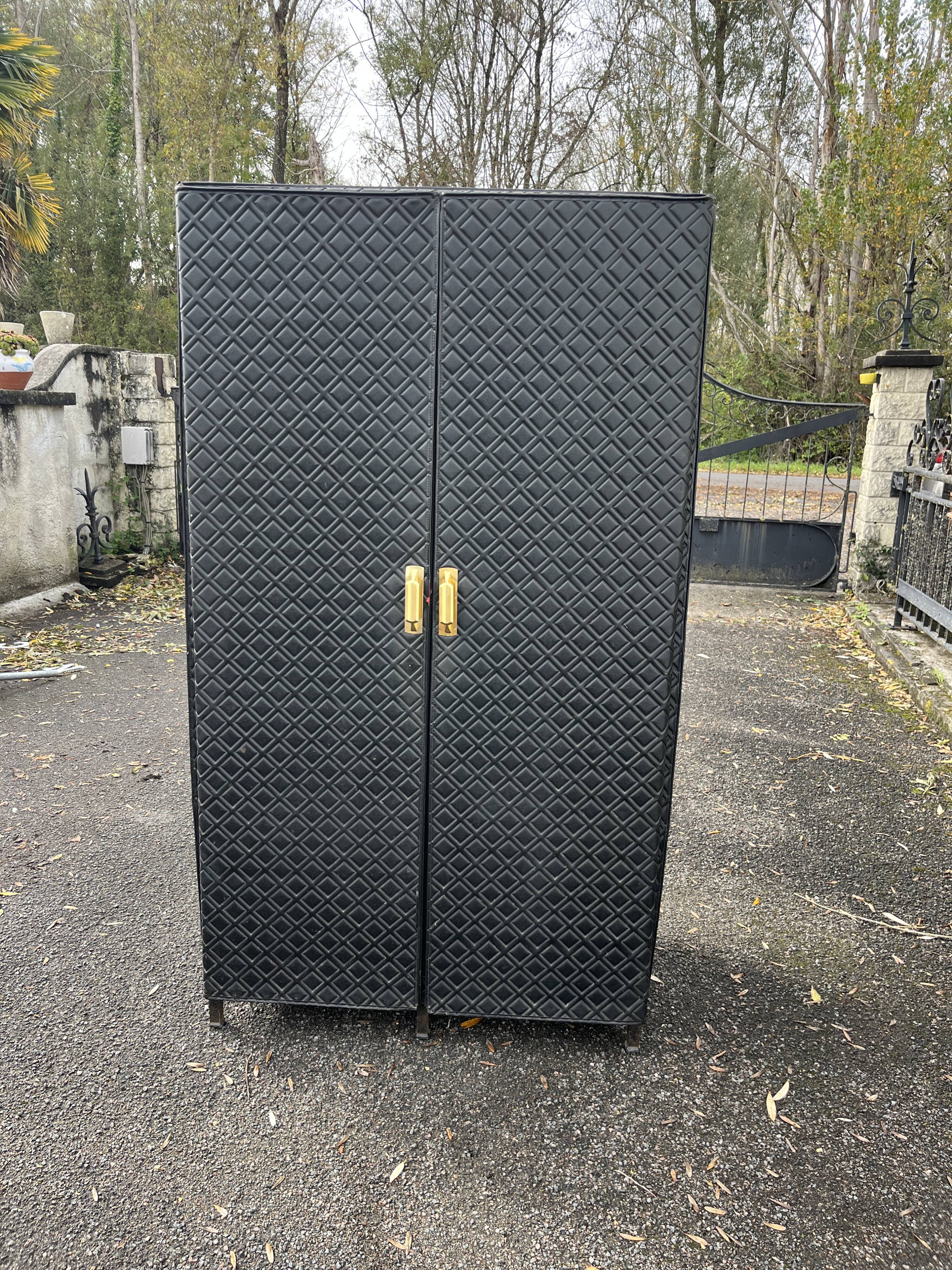Contemporary wardrobe in black faux leather with diamond pattern and gold handles.