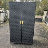 Contemporary wardrobe in black faux leather with diamond pattern and gold handles.