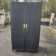 Contemporary wardrobe in black faux leather with diamond pattern and gold handles.