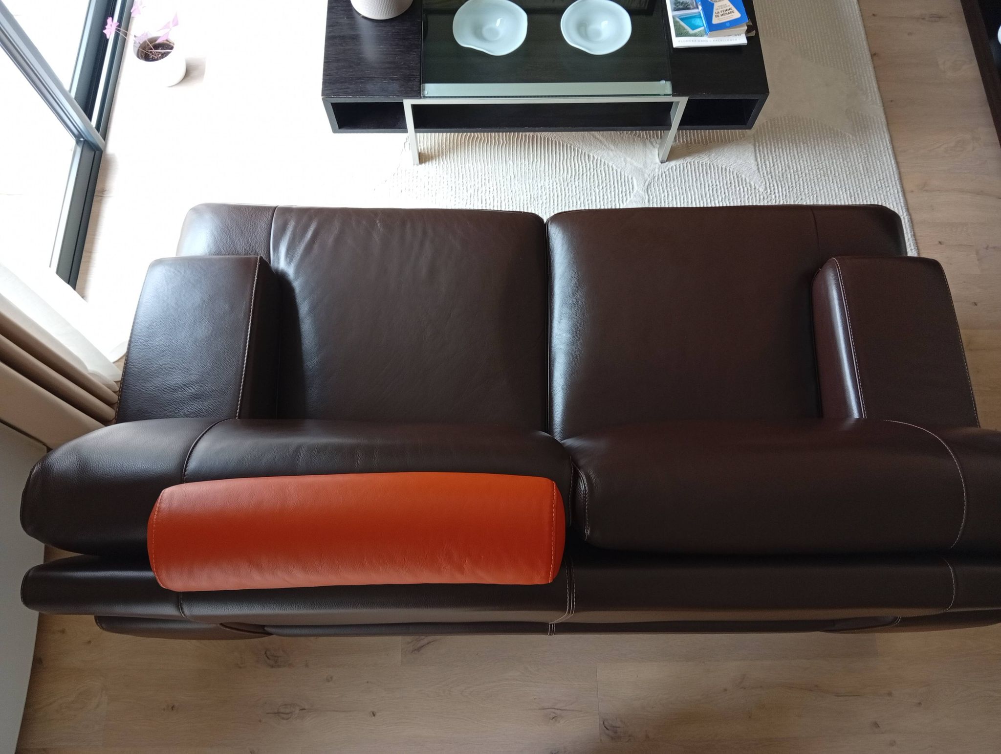 Two brown leather Crozatier two-and-a-half-seater sofas.