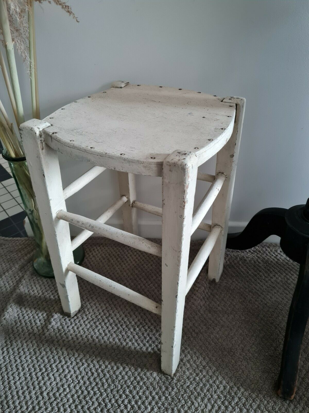 Vintage wooden stool with white peeling paint