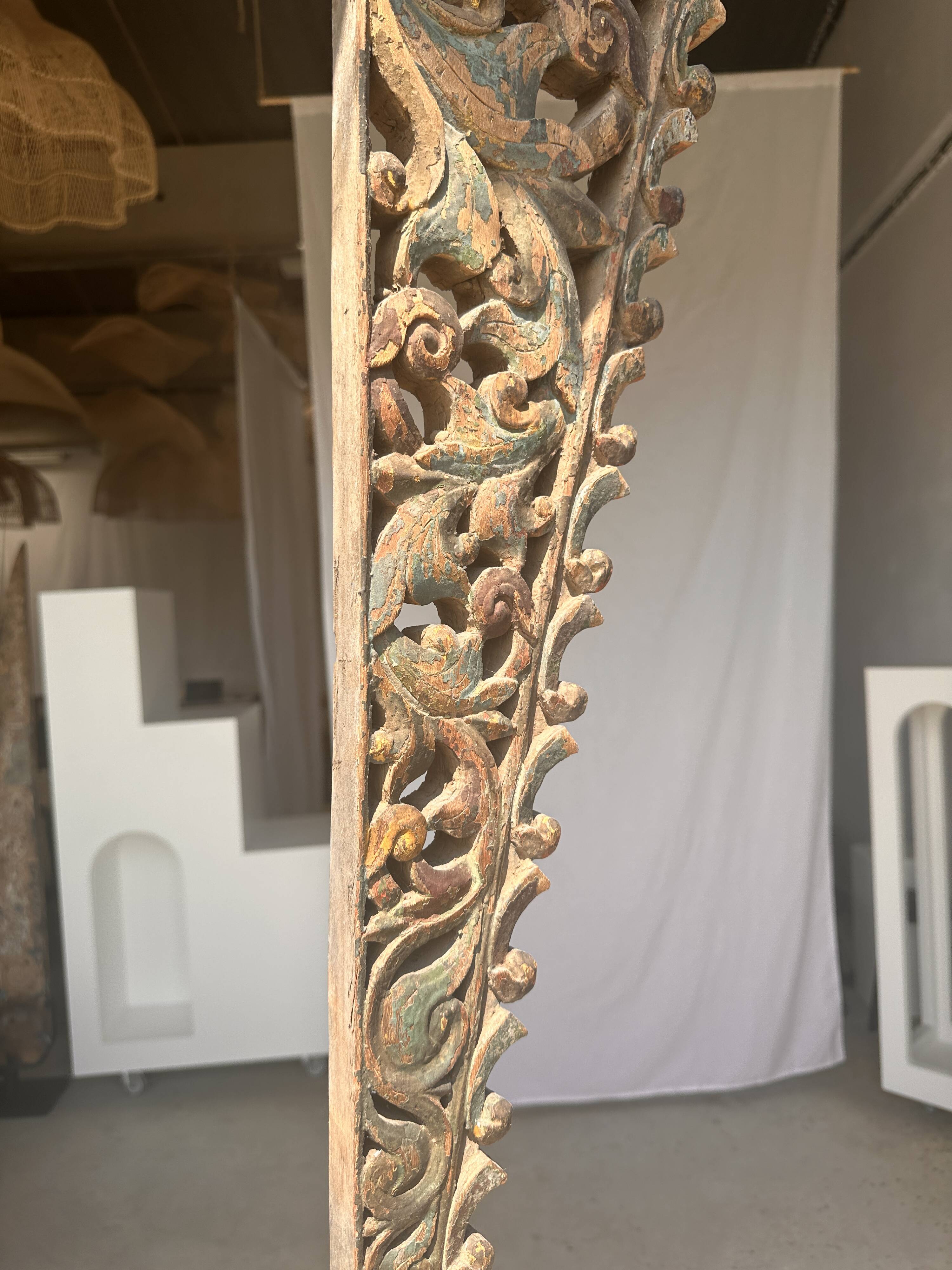 Indonesian construction element in carved wood with intertwined plant motifs mounted on a base (fri