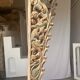 Indonesian construction element in carved wood with intertwined plant motifs mounted on a base (fri