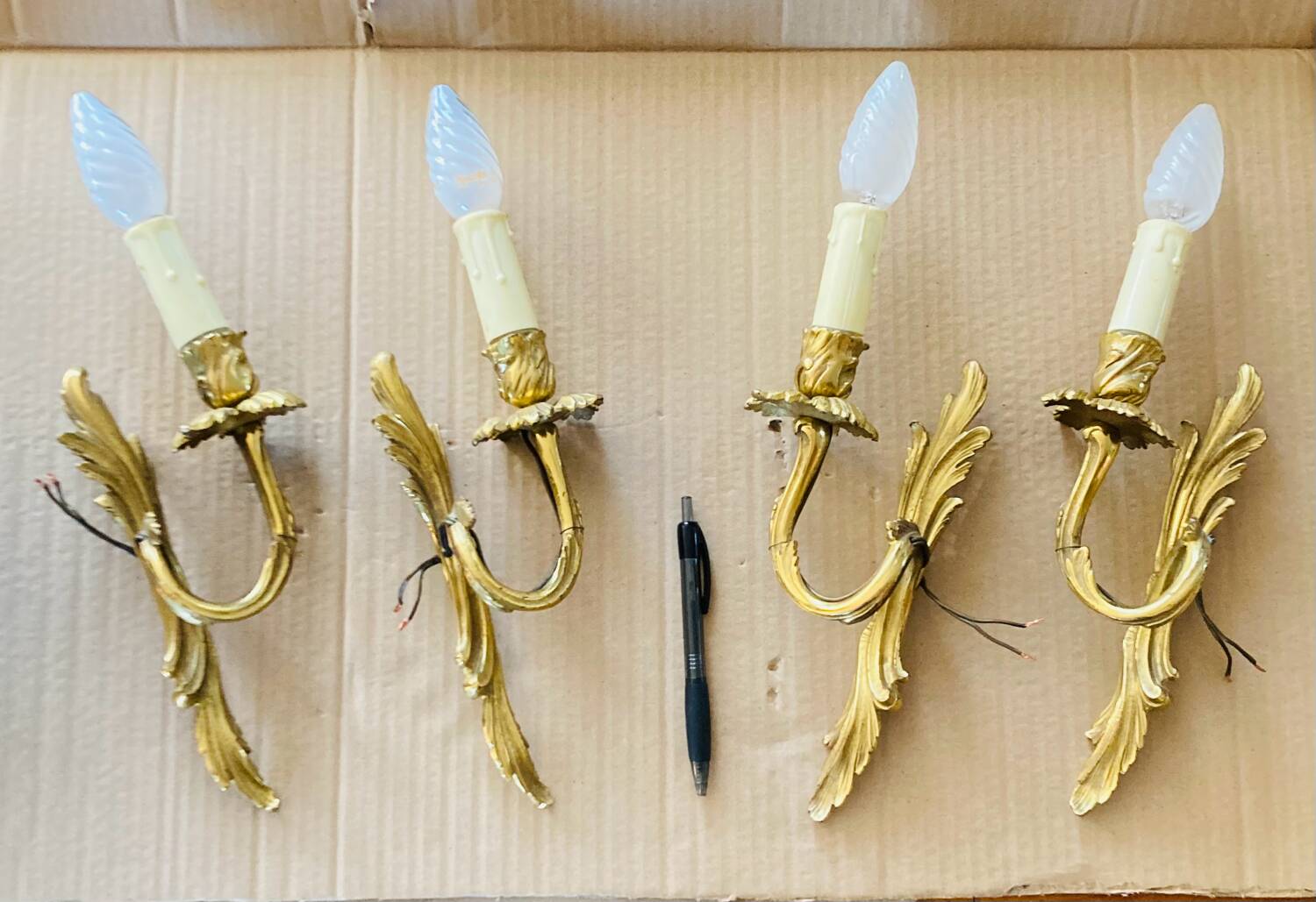 Bronze wall lights in the Louis XV style with curved branches and leaf decorations.